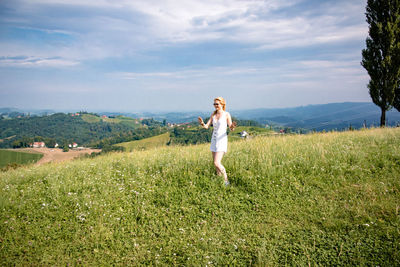 Woman standing on field against sky