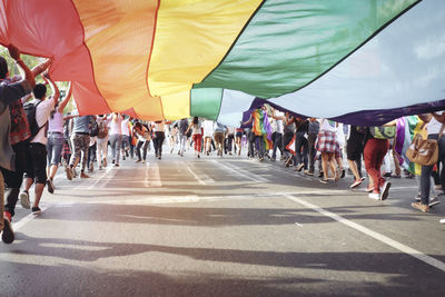 People holding flag while running on road