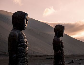 Statue of man standing on land against sky during sunset. chinchorro mummy .