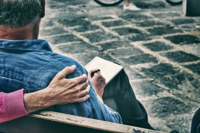 Rear view of man sitting on bench