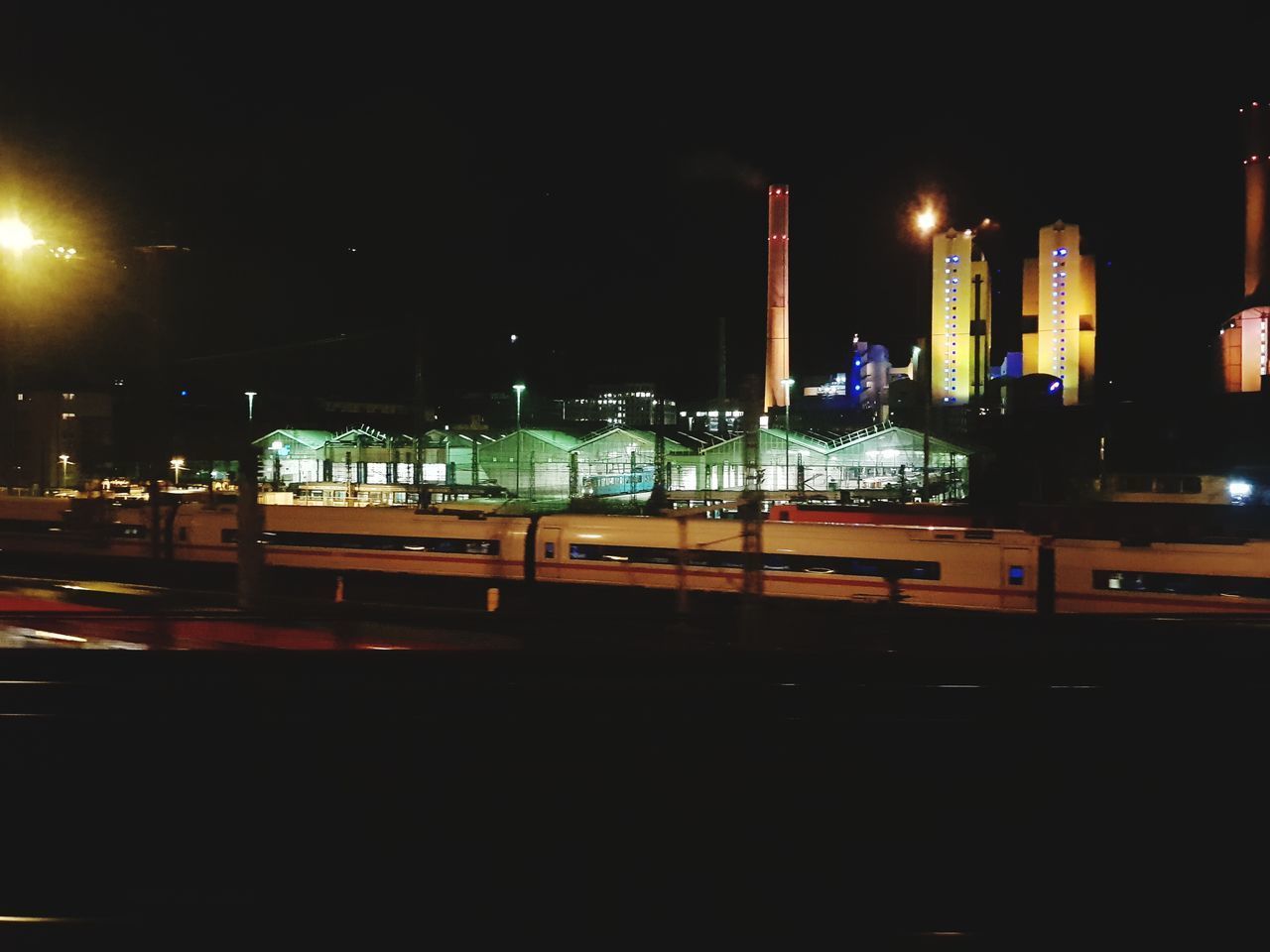 CARS ON ILLUMINATED STREET AGAINST SKY AT NIGHT