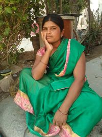 Portrait of a smiling young woman sitting outdoors