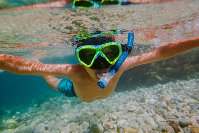 Portrait of shirtless boy swimming in sea