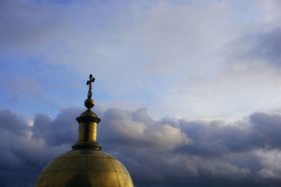 Low angle view of cross against building against sky