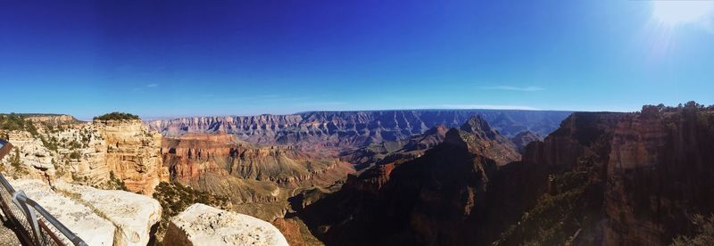 Panoramic view of rock formations against blue sky