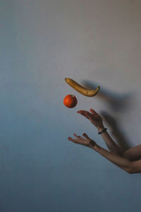 Hand holding fruit against white background