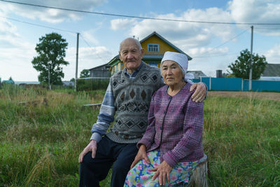 Portrait of  old people sitting on field