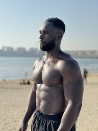 Portrait of shirtless man standing at beach