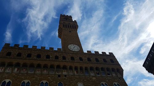 Low angle view of clock tower against cloudy sky