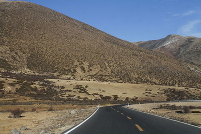 Road amidst desert against sky