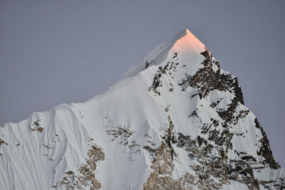 Low angle view of snowcapped mountain against clear sky