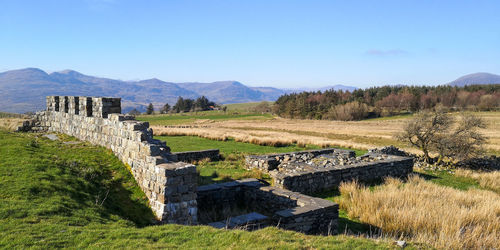 View of old ruins on field against sky