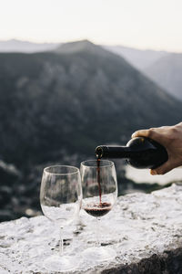 Person pouring wine in glass