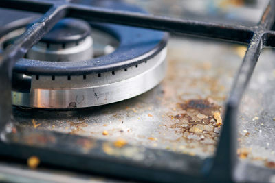 Dirty stove top with oil splatters, fat stains and food leftovers. unclean steel kitchen cooktop