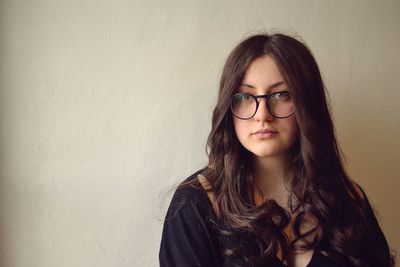 Portrait of a young woman against wall