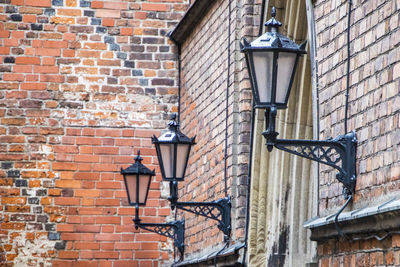 Illuminated street light against brick wall