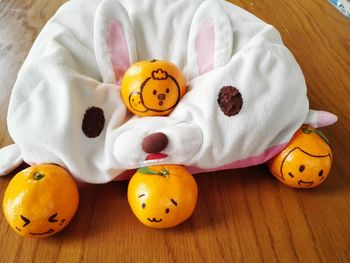 High angle view of oranges with anthropomorphic face and cushion