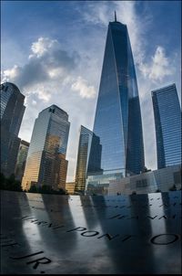 Low angle view of modern buildings against cloudy sky