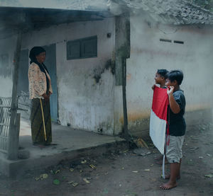 Full length of man and woman standing by building