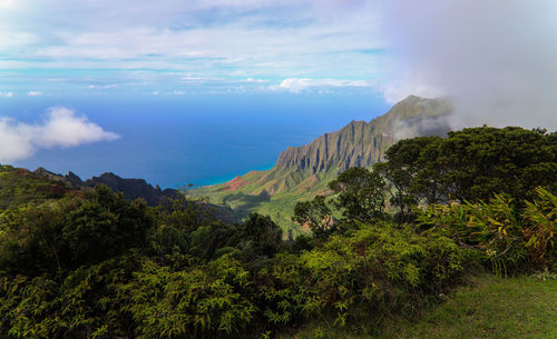 Scenic view of mountain by sea against sky