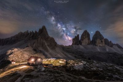 Scenic view of illuminated mountains against sky at night