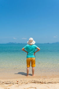 Rear view of  senior woman enjoy white beach and blue sea of tropical island during summer vacation