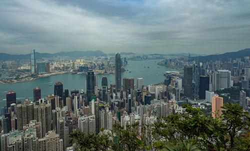 Aerial view of cityscape against cloudy sky