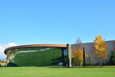 Built structure on field against clear blue sky