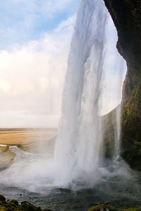 Scenic view of waterfall against sky