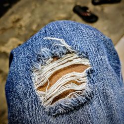 Cropped image of person wearing torn jeans