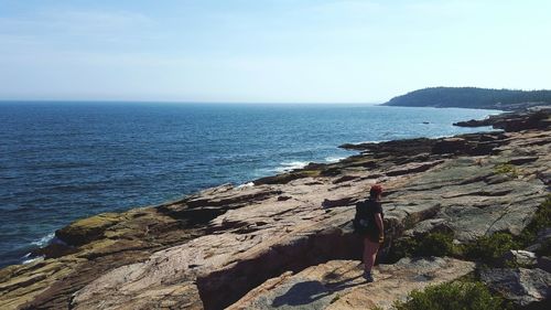 Scenic view of person standing on rocky shore