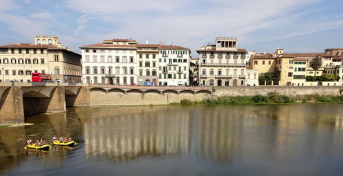 Reflection of buildings in river against sky