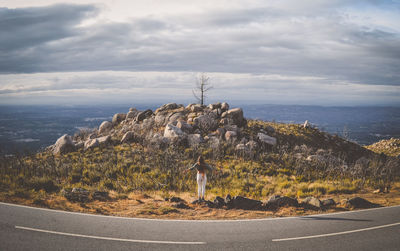 Man standing by mountain against sky