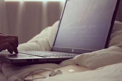 Close-up of woman using laptop at home