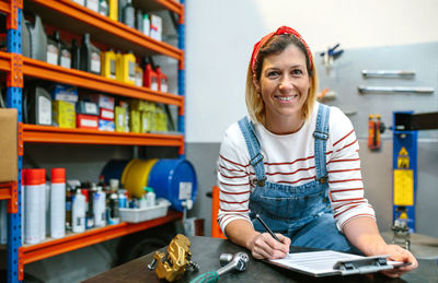 Woman checking stock in mechanic workshop