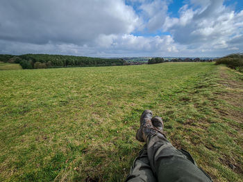 Sitting with legs crossed in field with hiking boots on