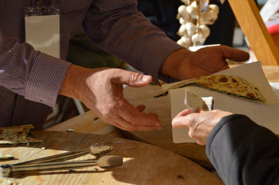 Close-up of hand holding hands on table