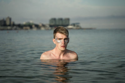 Portrait of shirtless man in sea