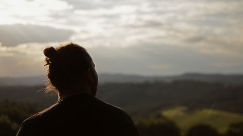 Rear view of woman looking at sunset