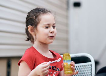 Cute little girl is blowing soap bubbles in the backyard