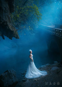 Woman standing with umbrella in water