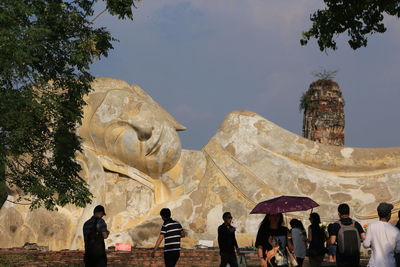 People at historical building against sky