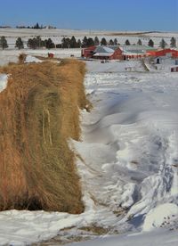 Haystack and houses in deep snow in winter