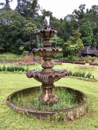 Fountain by trees against sky