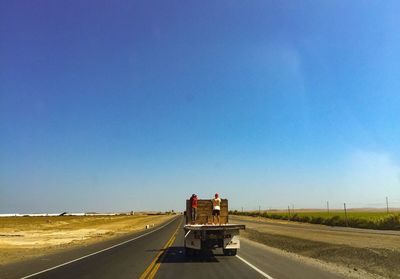 Road against clear blue sky