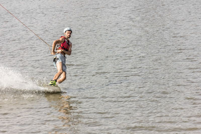 Full length of a young man surfing in water