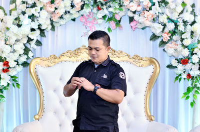 Full length of man standing by flowering plants