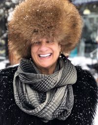 Portrait of cheerful woman wearing fur hat in winter