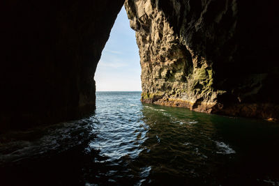 Scenic view of rock formation in sea against sky