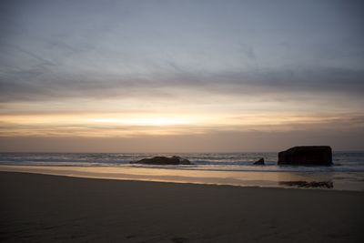 Scenic view of beach against sky during sunset